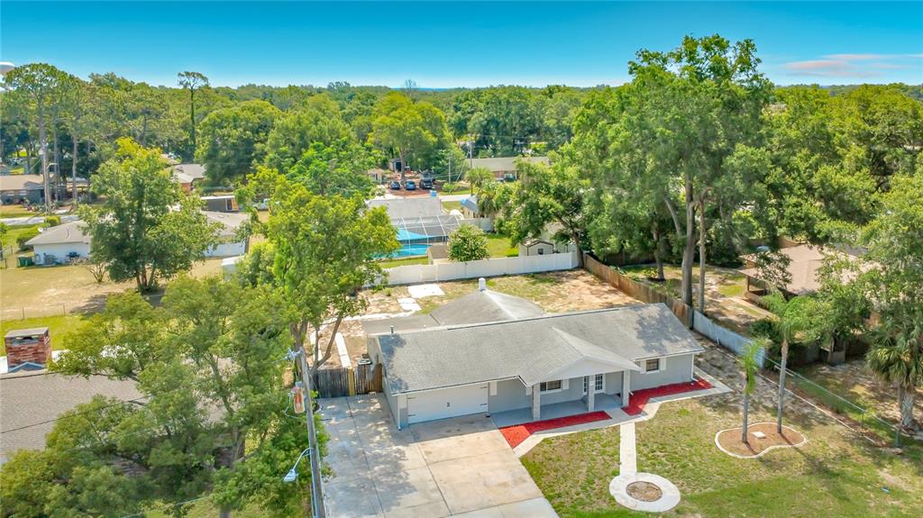 An aerial view of a single-story house with a concrete driveway and a large yard — 501 ROSE AVENUE, FRUITLAND PARK, FL