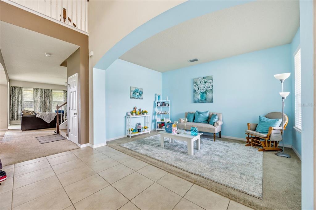 A living room features light blue walls, a beige sofa, and a gray area rug — 2820 CYPRESS GROVE COURT, ST CLOUD, FL