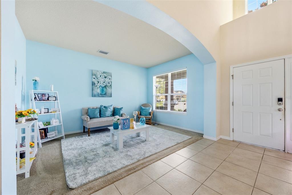 A living room with light blue walls, a white coffee table, and a gray rug — 2820 CYPRESS GROVE COURT, ST CLOUD, FL