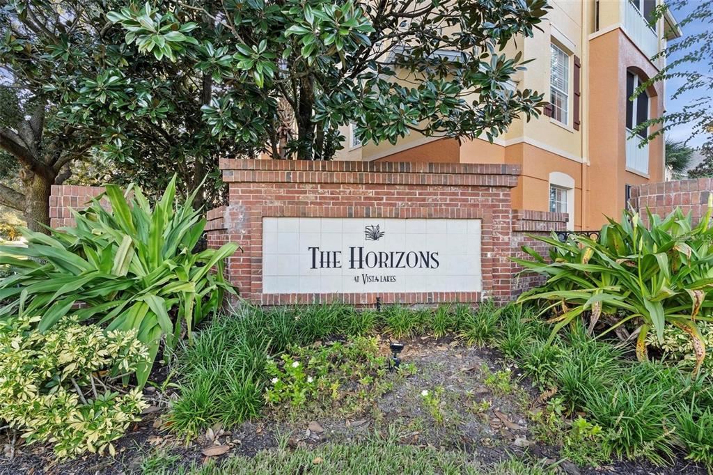 A brick monument sign for The Horizons at Vista Lakes stands before an apartment building — 6265 CONTESSA DRIVE UNIT 210, ORLANDO, FL