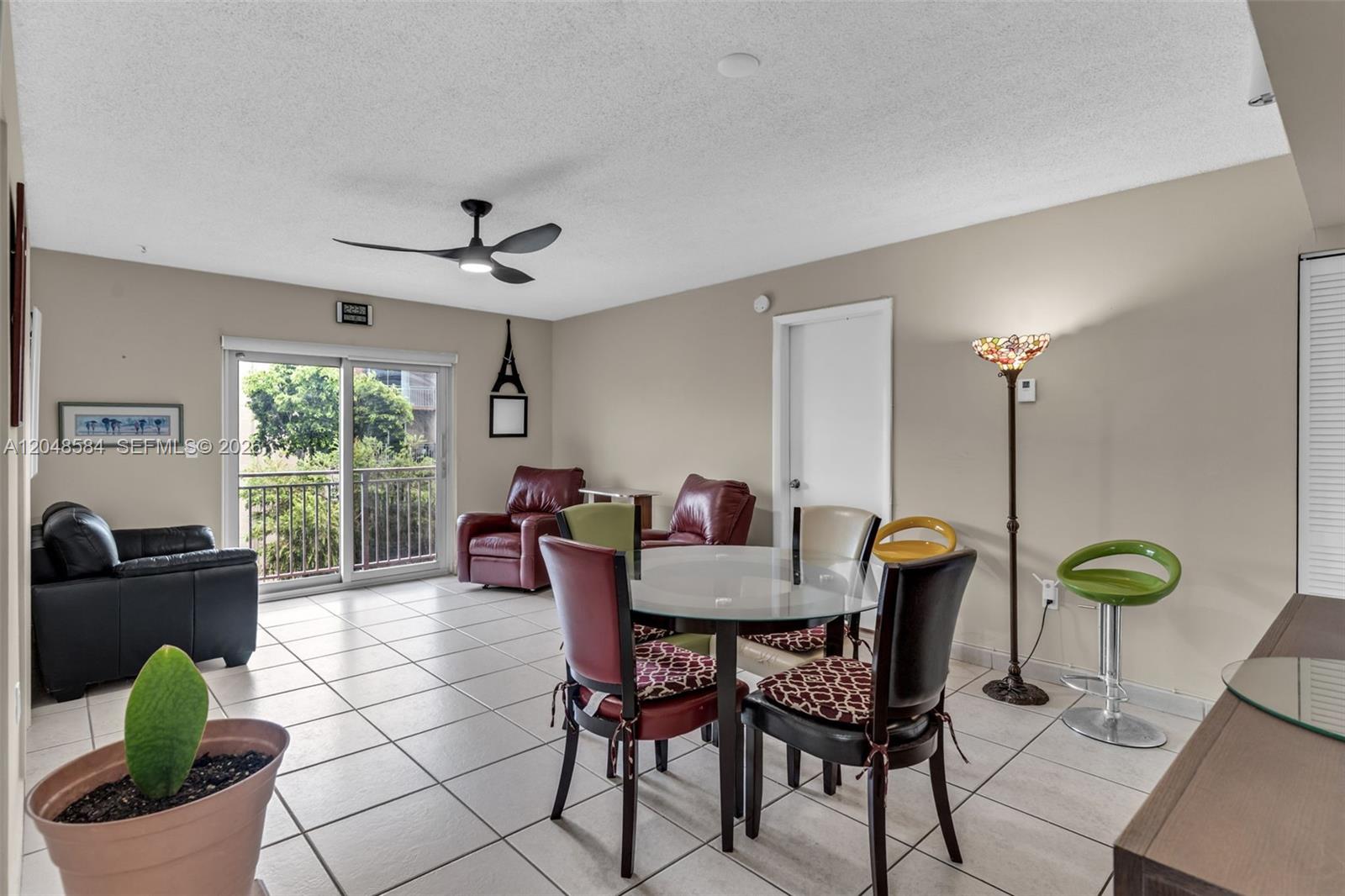 A living and dining area features tile flooring, a glass table, and a sliding glass door — 4715 NW 7th St # 2, Miami FL 33126, MIAMI, FL