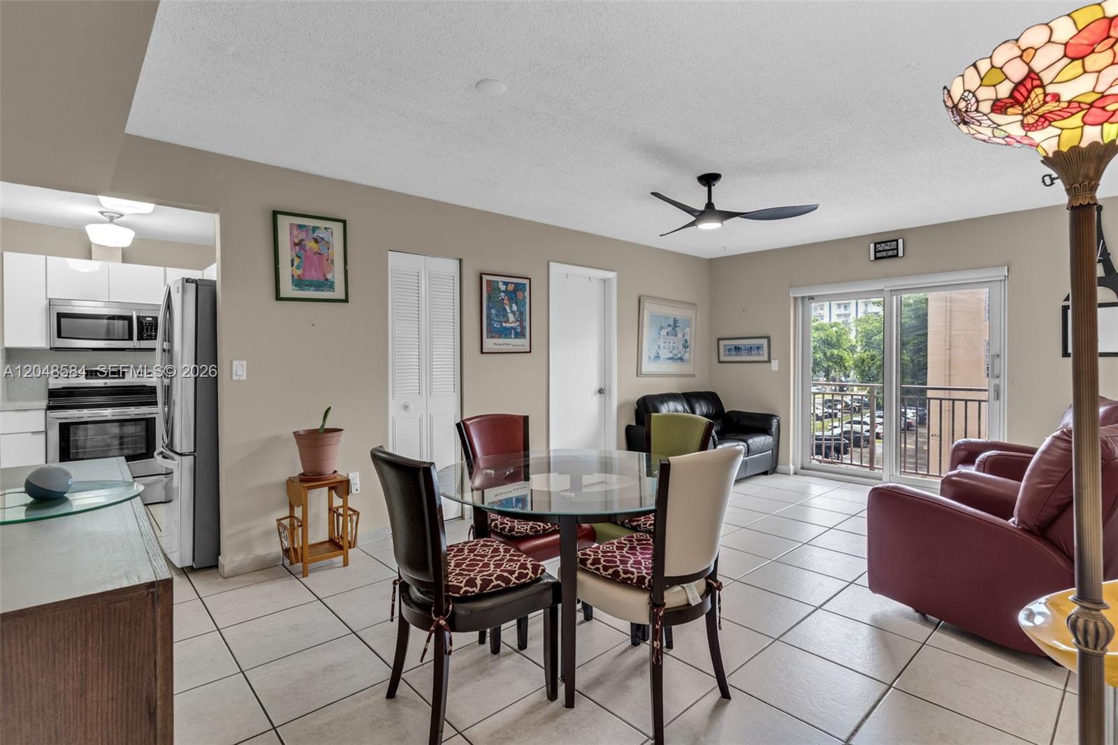 A dining area with a glass table and chairs sits adjacent to a modern kitchen — 4715 NW 7th St # 2, Miami FL 33126, MIAMI, FL