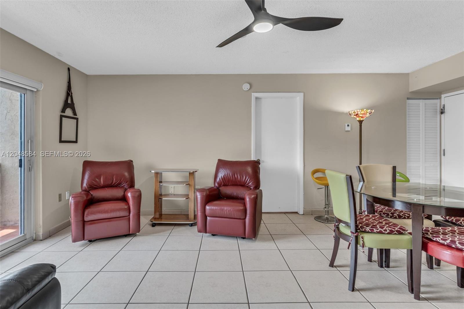 A living and dining area features tile flooring, two red leather recliners, and a ceiling fan — 4715 NW 7th St # 2, Miami FL 33126, MIAMI, FL