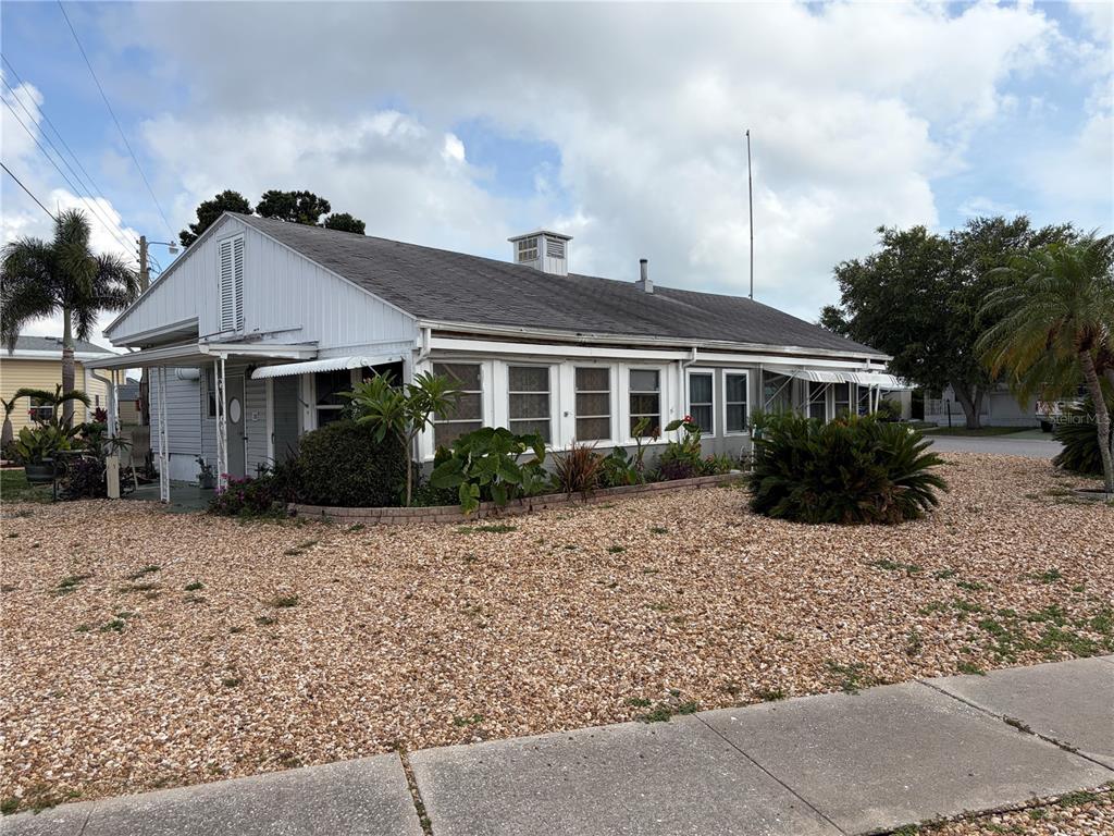 A single-story house with a gravel yard, white siding, and a dark shingled roof — 5066 PEBBLE BEACH AVENUE, SARASOTA, FL