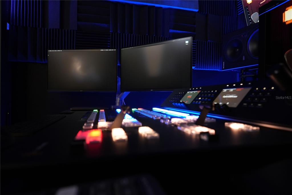 A professional recording studio features a large mixing console, dual computer monitors, and acoustic wall panels — 4705 S APOPKA VINELAND ROAD UNIT 210, ORLANDO, FL