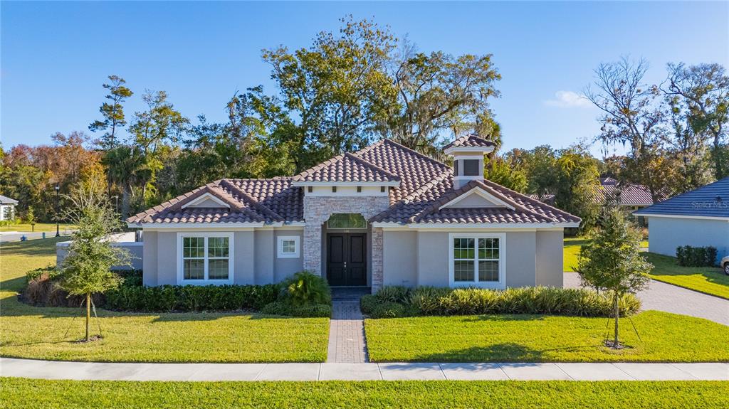 A single-story house with a tiled roof, stone facade, and a paved walkway — 106 NEW LEATHERWOOD DRIVE, PALM COAST, FL