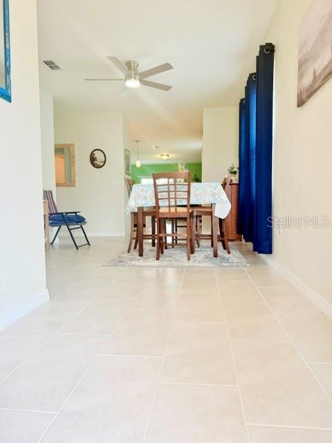 A dining area features a table with chairs, tile flooring, and blue curtains — 2579 SAGE VALLEY WAY, WINTER HAVEN, FL