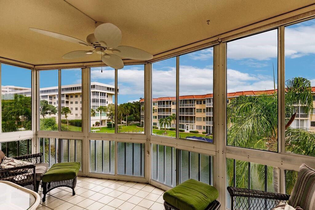 A screened-in balcony with tile flooring, a ceiling fan, and views of a nearby lake — 1250 N PORTOFINO DRIVE UNIT 302, SARASOTA, FL