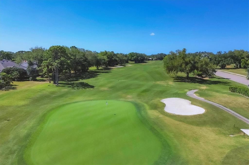 An aerial view of a golf course green with a sand bunker and surrounding trees — 2087 TIMUCUA TRAIL, NOKOMIS, FL