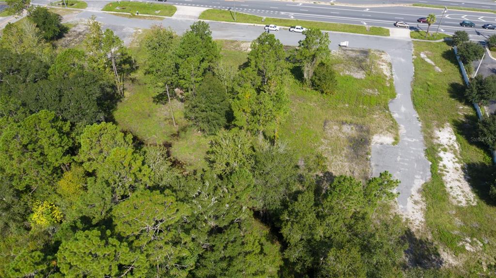 An aerial view shows a vacant, partially wooded lot adjacent to a paved road — 00 S WALNUT STREET, STARKE, FL