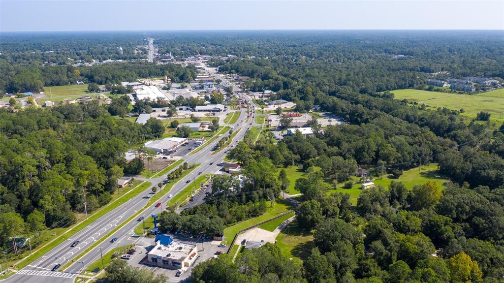 An aerial view shows a highway running through a forested area with commercial buildings — 00 S WALNUT STREET, STARKE, FL