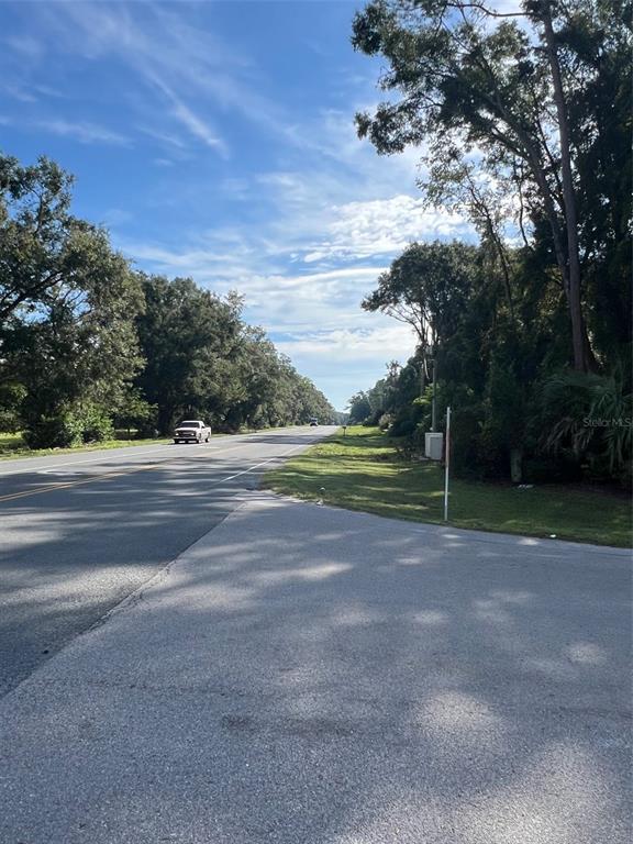 A paved road stretches into the distance, flanked by trees and a grassy shoulder — 16604 NW STATE ROAD 45, HIGH SPRINGS, FL