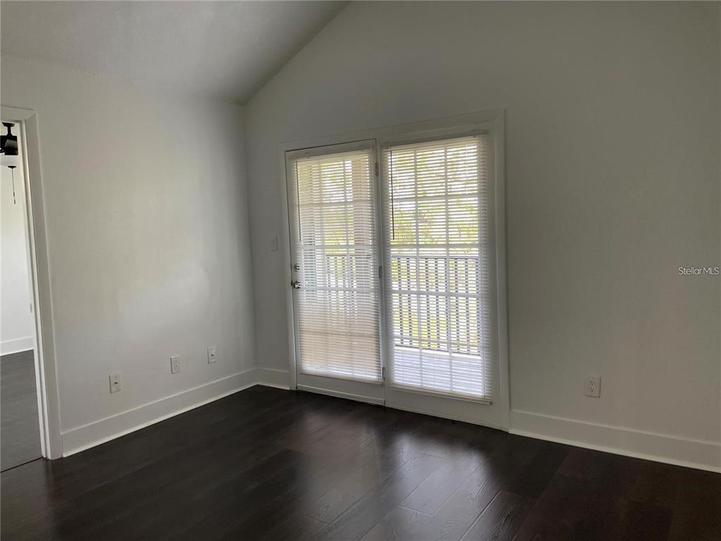A room with dark wood flooring, white walls, and glass French doors leading outside — 199 AFTON SQUARE UNIT 309, ALTAMONTE SPRINGS, FL