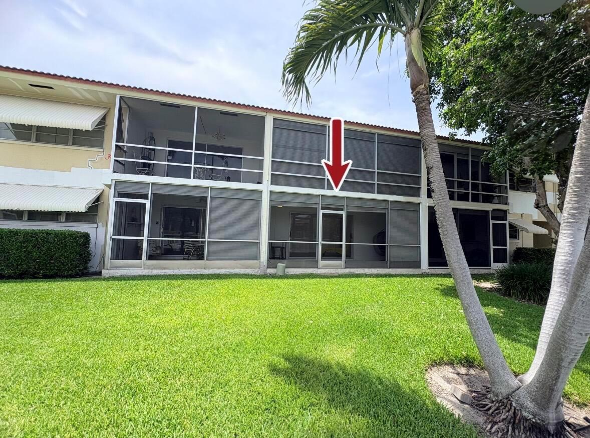 The exterior of a two-story apartment building features screened-in balconies and a grassy lawn — 2202 NE 36th Street # 17, Lighthouse Point FL 33064, LIGHTHOUSE POINT, FL