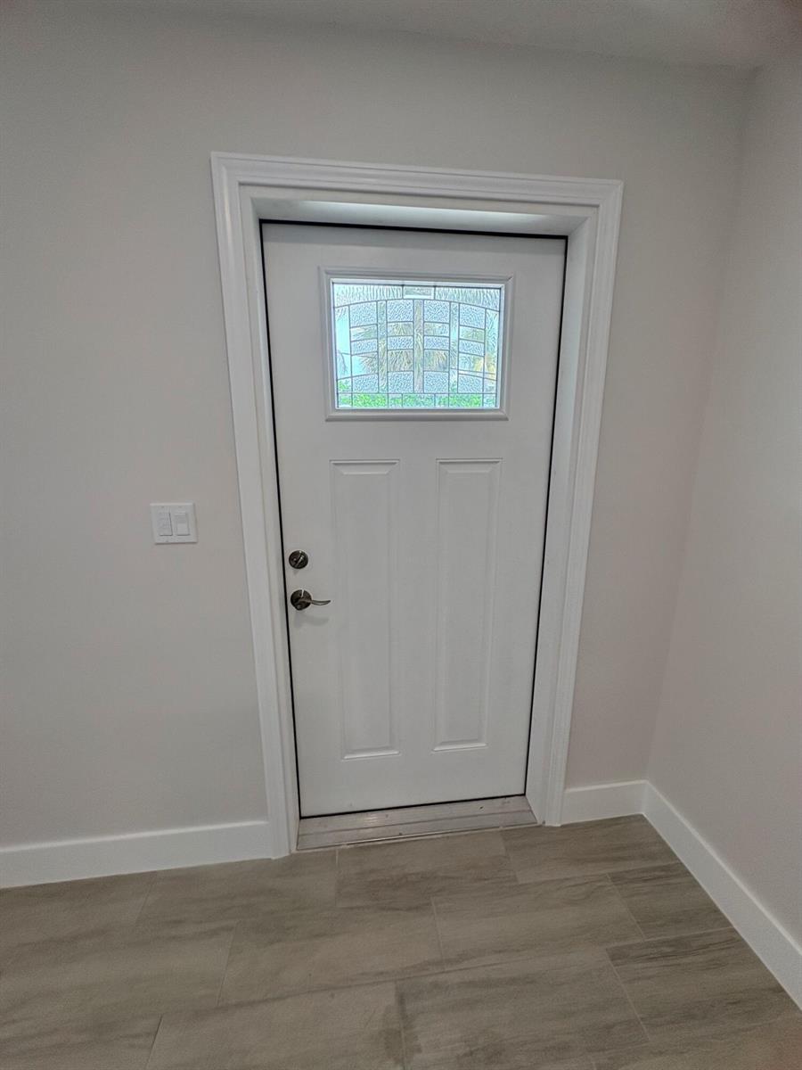 A white door with a decorative glass window is set in a light-colored room — 2202 NE 36th Street # 17, Lighthouse Point FL 33064, LIGHTHOUSE POINT, FL