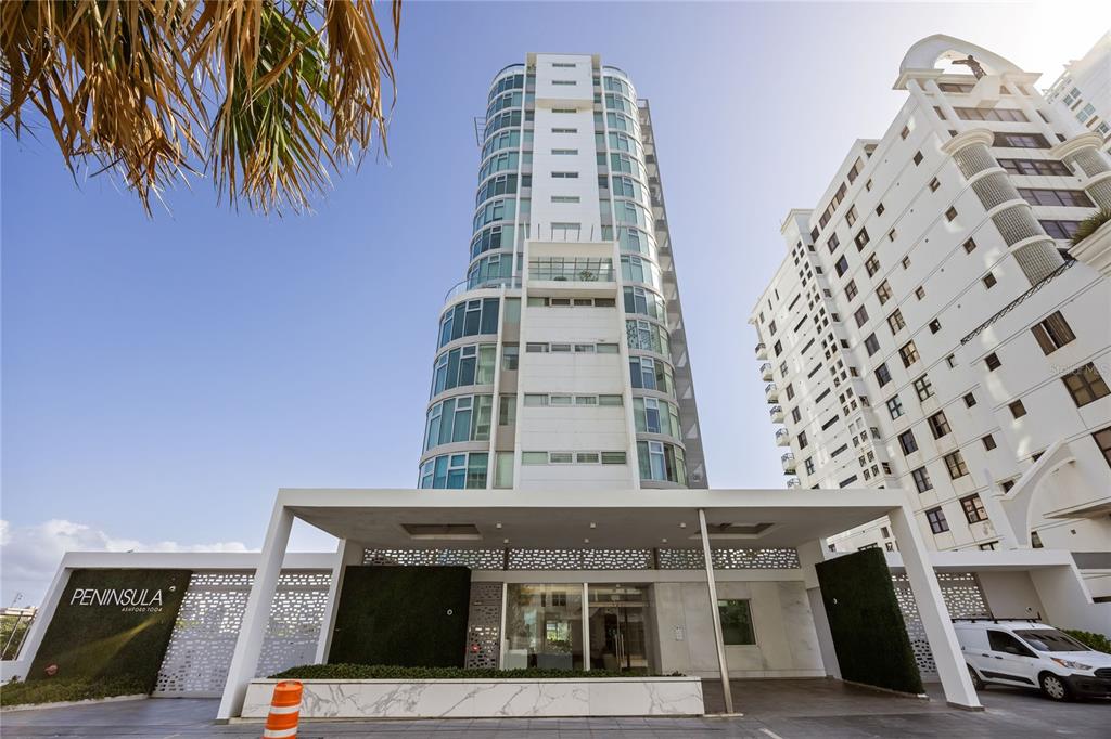 A modern high-rise residential building features a glass facade and a white marble entrance canopy — 1002 ASHFORD AVENUE UNIT 14, CONDADO, PR