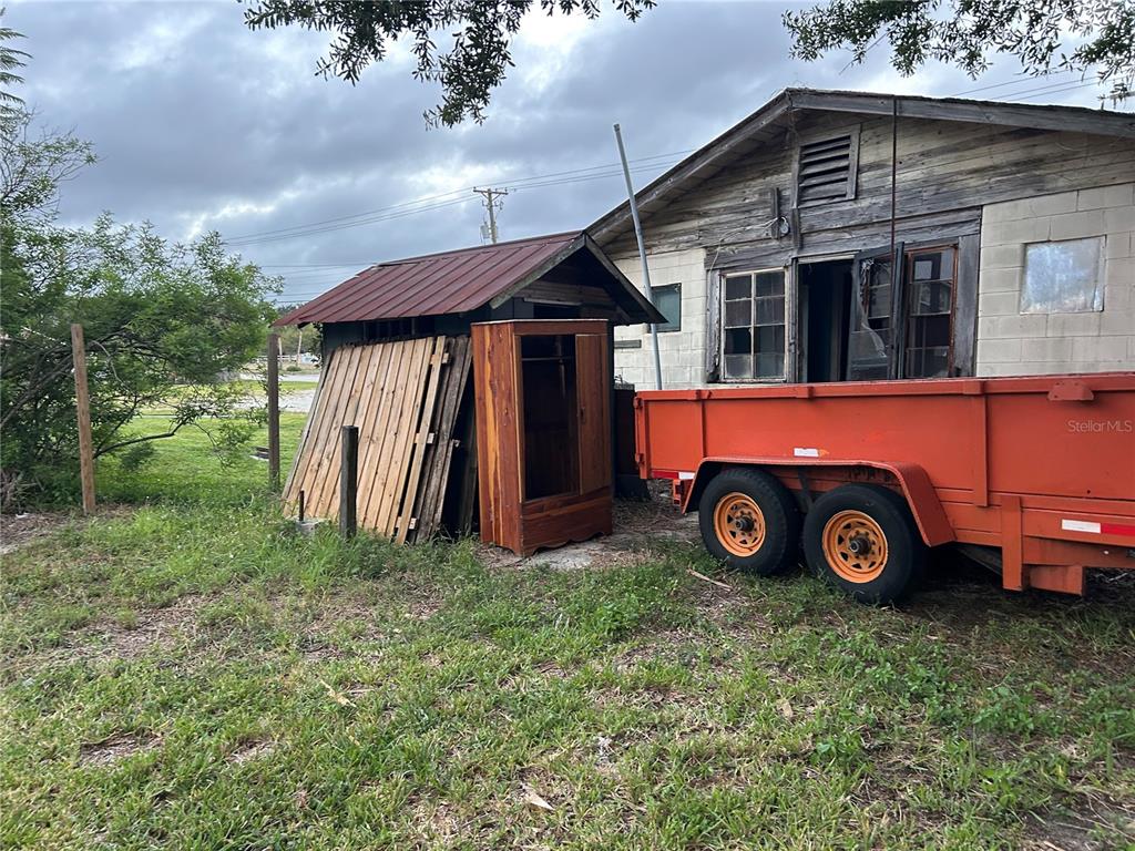 An orange dump trailer sits beside a small shed and an old, weathered building — 2844 LAKE ALFRED ROAD, WINTER HAVEN, FL