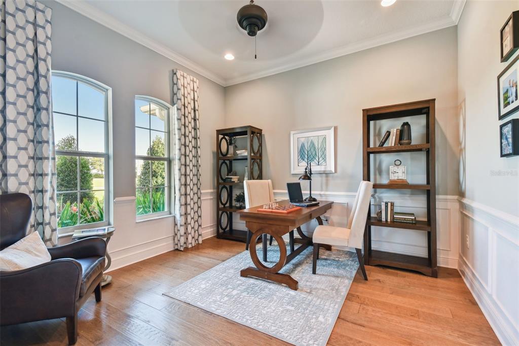 A home office features a wooden desk, two bookshelves, a leather chair, and large windows — 5333 LAKE VENICE DRIVE, WIMAUMA, FL