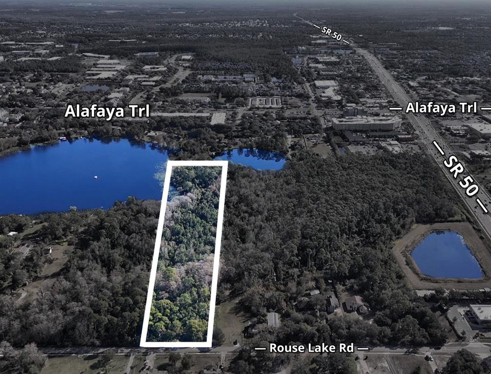 An aerial view shows a rectangular wooded lot outlined in white near a lake — 1893 ROUSE LAKE ROAD, ORLANDO, FL