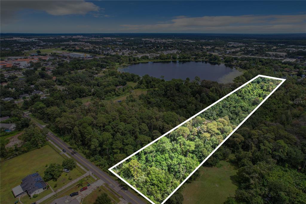 An aerial view shows a rectangular, tree-covered plot of land outlined in white — 1893 ROUSE LAKE ROAD, ORLANDO, FL