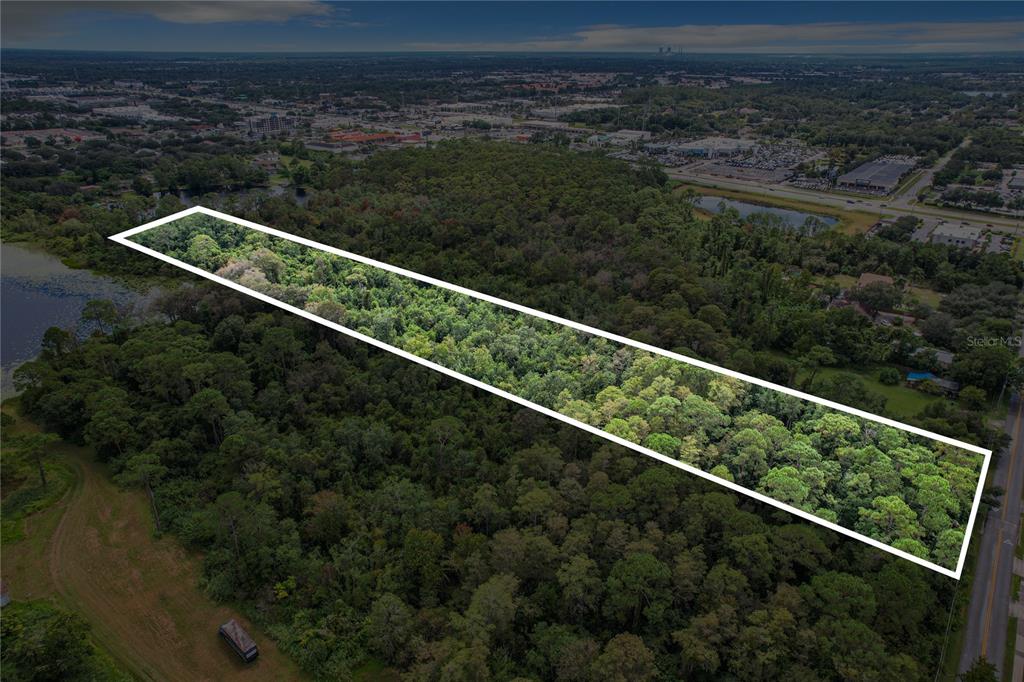 An aerial view shows a rectangular plot of land outlined in white amidst dense forest — 1893 ROUSE LAKE ROAD, ORLANDO, FL