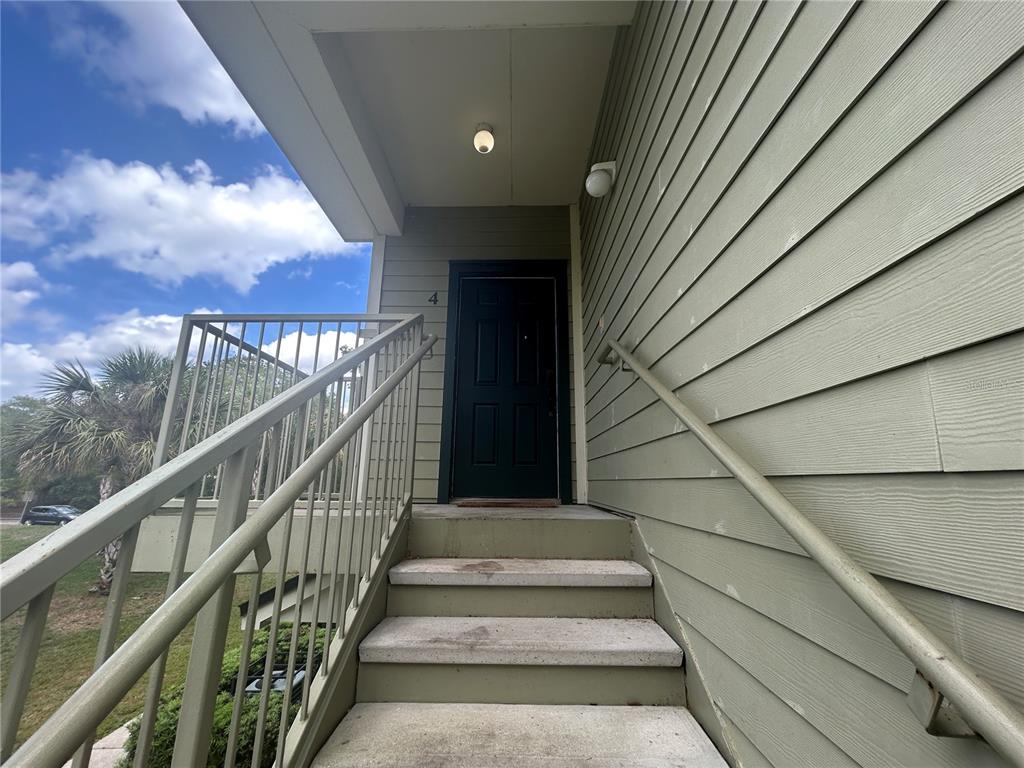 An exterior view shows a set of concrete stairs leading to a dark front door — 3721 S LAKE ORLANDO PARKWAY UNIT 4, ORLANDO, FL