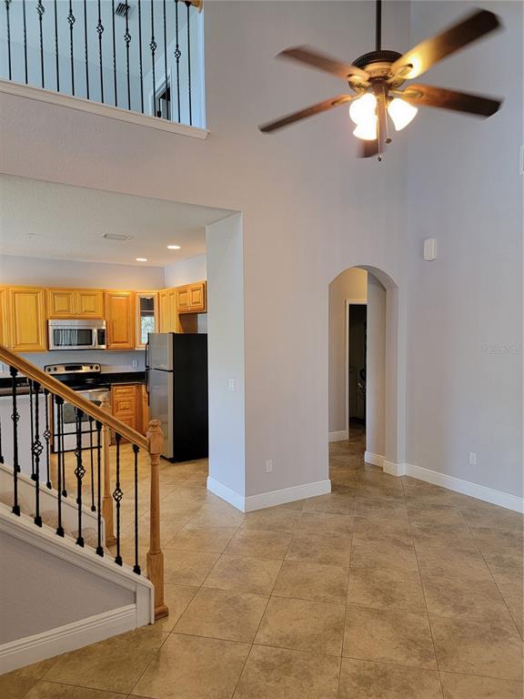 A view of a kitchen with oak cabinets and a staircase with iron railings — 3721 S LAKE ORLANDO PARKWAY UNIT 4, ORLANDO, FL