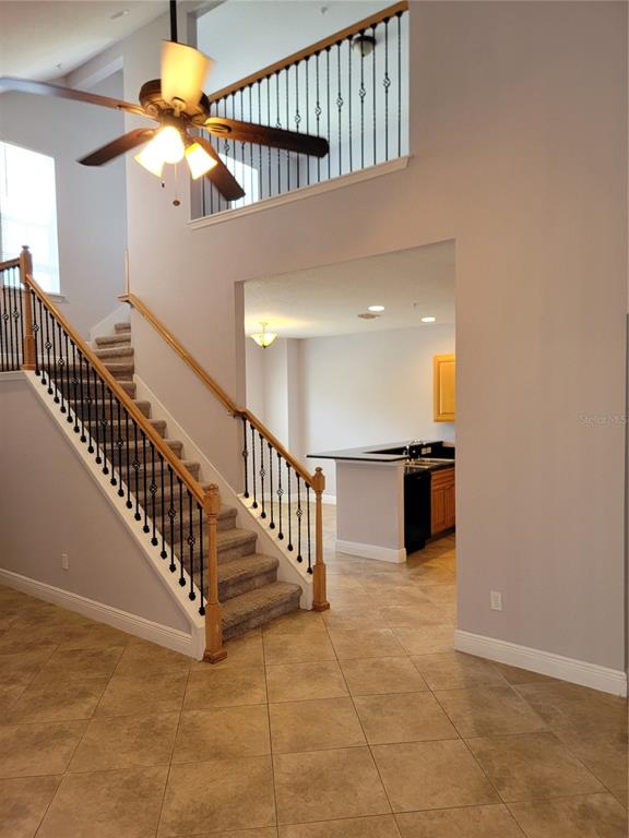 A staircase with iron railings leads to an upper landing overlooking a kitchen area — 3721 S LAKE ORLANDO PARKWAY UNIT 4, ORLANDO, FL