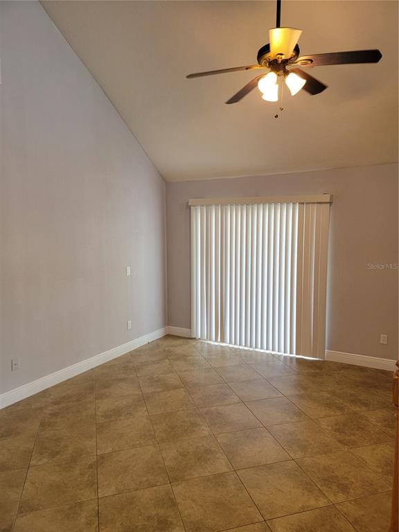 A room with light gray walls, tile flooring, a vaulted ceiling, and vertical window blinds — 3721 S LAKE ORLANDO PARKWAY UNIT 4, ORLANDO, FL