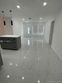 An open-concept living area features white marble-look tile flooring, recessed lighting, and a kitchen island — 751 NW 18 Street, Pompano Beach FL 33060, POMPANO BEACH, FL