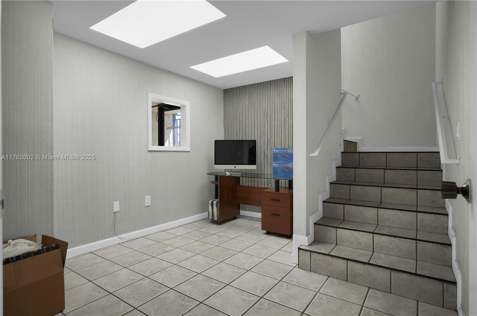 A room with tiled floors, a desk, and a staircase leading to an upper level — 5220 NW 72nd Ave # A1, Miami FL 33166, MIAMI, FL