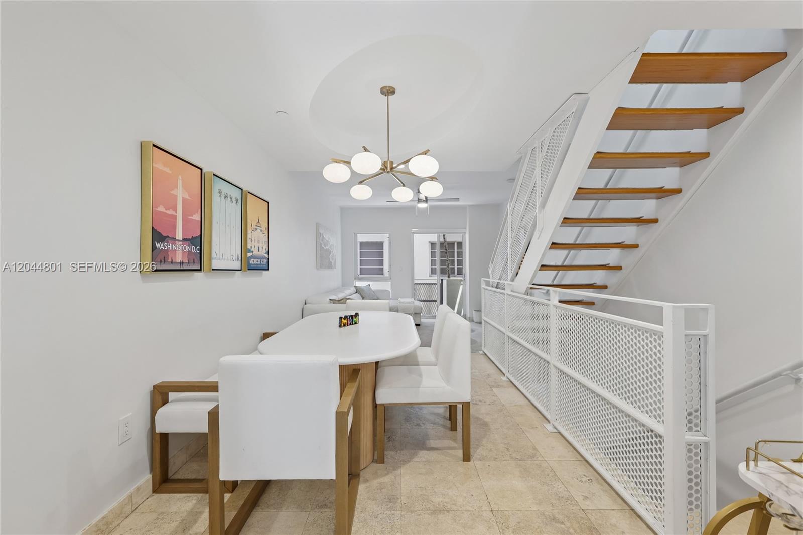 A dining area features a white oval table, modern chairs, and an open staircase — 204 Washington Ave # 13, Miami Beach FL 33139, MIAMI BEACH, FL