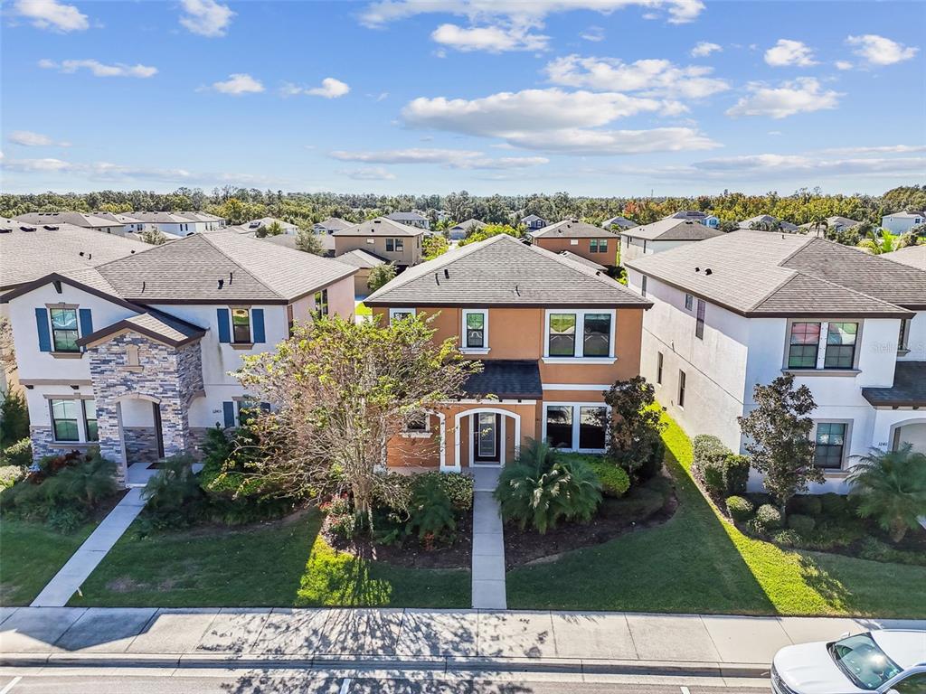 An aerial view shows a two-story suburban house with a tan exterior and brown roof — 12413 TRIPLE CREEK BOULEVARD, RIVERVIEW, FL