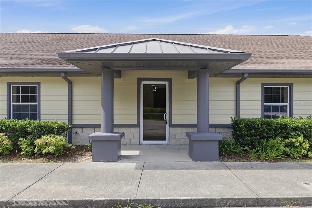 The exterior of a single-story building features a covered entryway with two gray columns — 4390 NE 35TH STREET UNIT 2, OCALA, FL