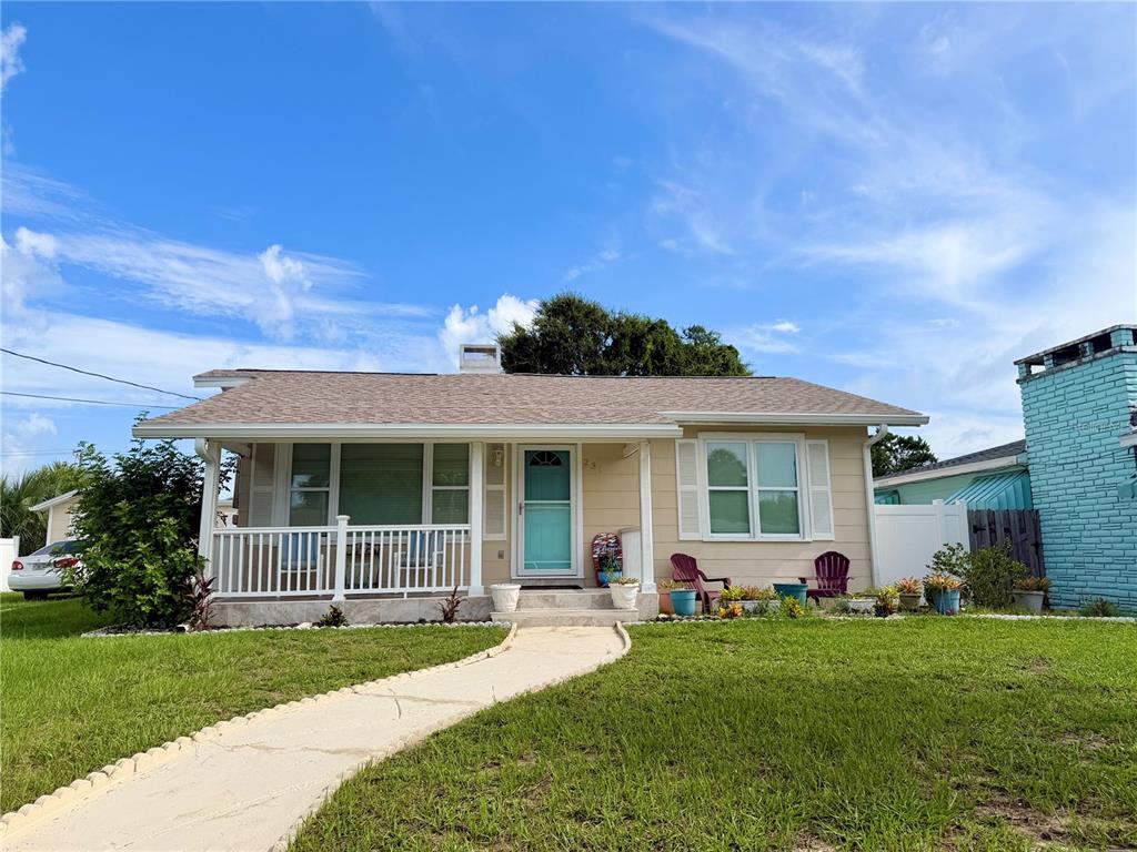 A single-story house with tan siding, a front porch, and a turquoise front door — 231 WILLIAMS AVENUE, DAYTONA BEACH, FL