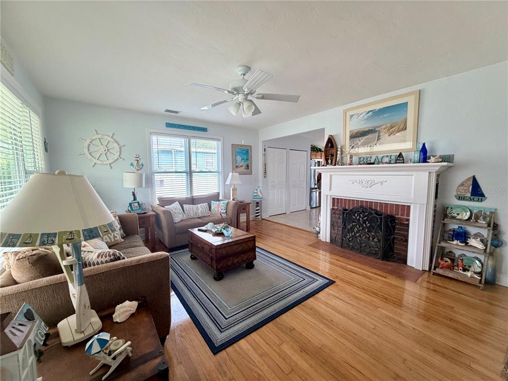 A living room features hardwood floors, a brick fireplace, and coastal-themed decor — 231 WILLIAMS AVENUE, DAYTONA BEACH, FL