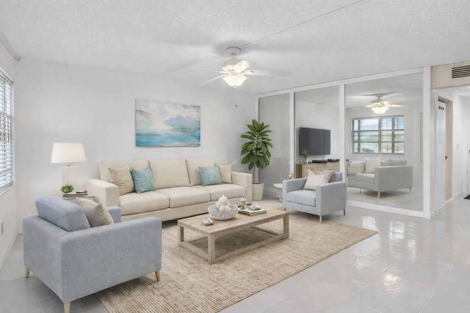 A living room features a beige sofa, two light blue armchairs, and a mirrored wall — 3010 Guildford A, Boca Raton FL 33434, BOCA RATON, FL