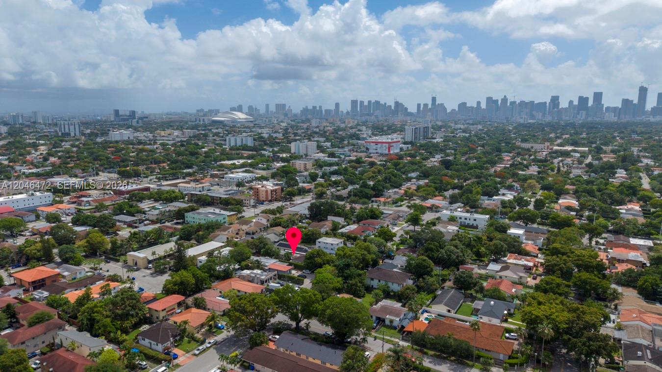 An aerial view shows a residential neighborhood with a red pin marking a specific property — MIAMI, FL