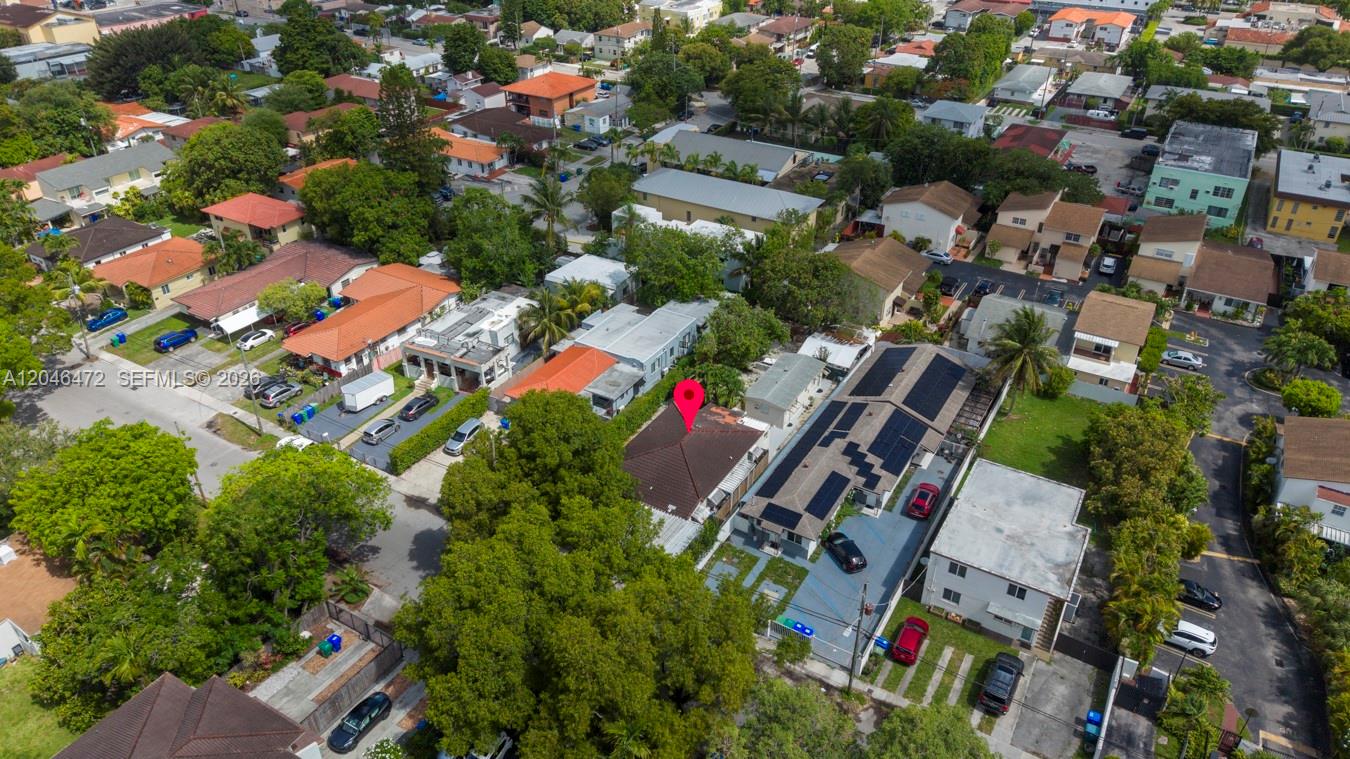 An aerial view shows a residential neighborhood with houses, driveways, and a red location pin — MIAMI, FL