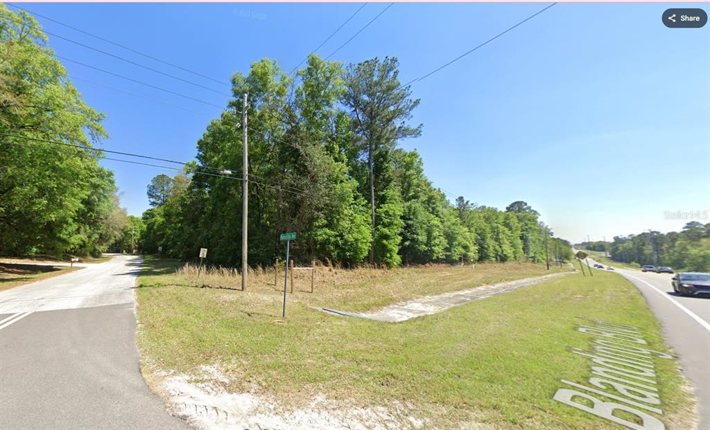A wooded corner lot sits at the intersection of a paved road and a highway — 2745 POINSETTIA AVENUE, MIDDLEBURG, FL