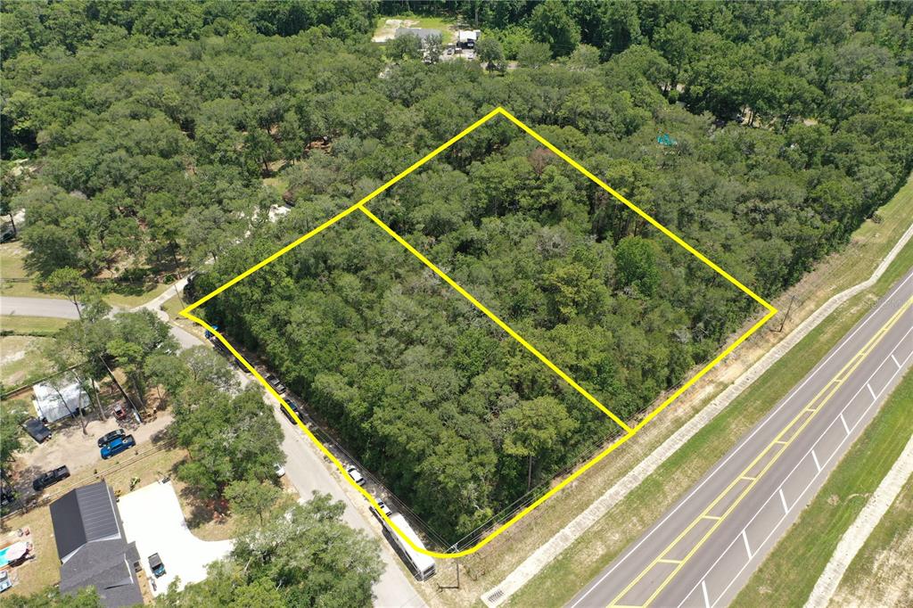 An aerial view shows two adjacent wooded lots bordered by a road and a highway — 2745 POINSETTIA AVENUE, MIDDLEBURG, FL