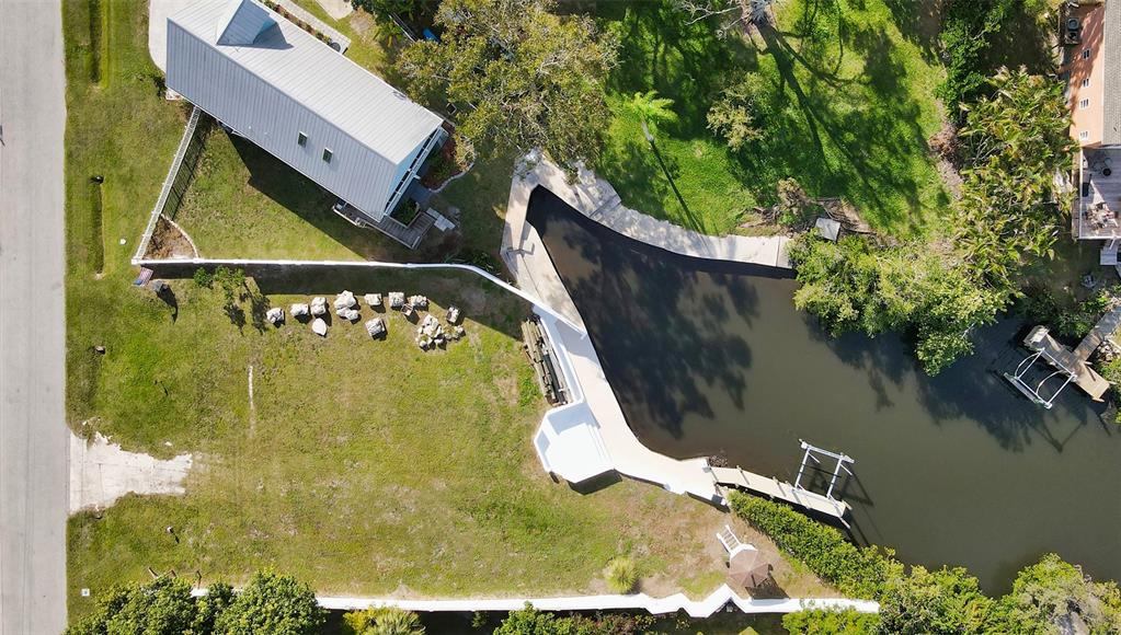 An aerial view shows a house with a metal roof next to a canal — 223 RAVENNA STREET, NOKOMIS, FL