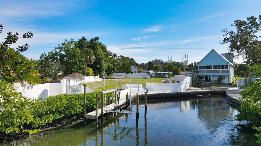A waterfront property features a boat dock, a white gazebo, and a light blue house — 223 RAVENNA STREET, NOKOMIS, FL