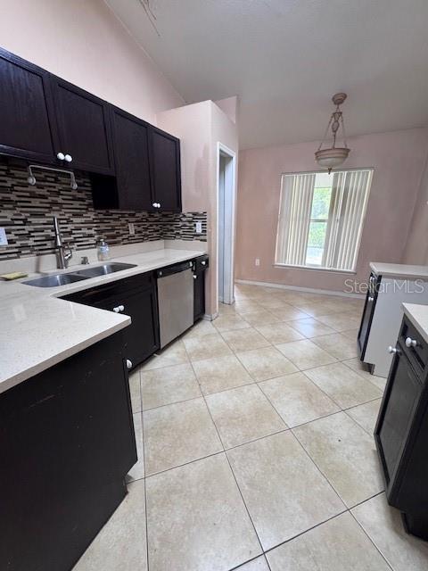 A kitchen with dark cabinets, light countertops, and tile flooring opens into a dining area — 338 KINGFISH DRIVE, KISSIMMEE, FL