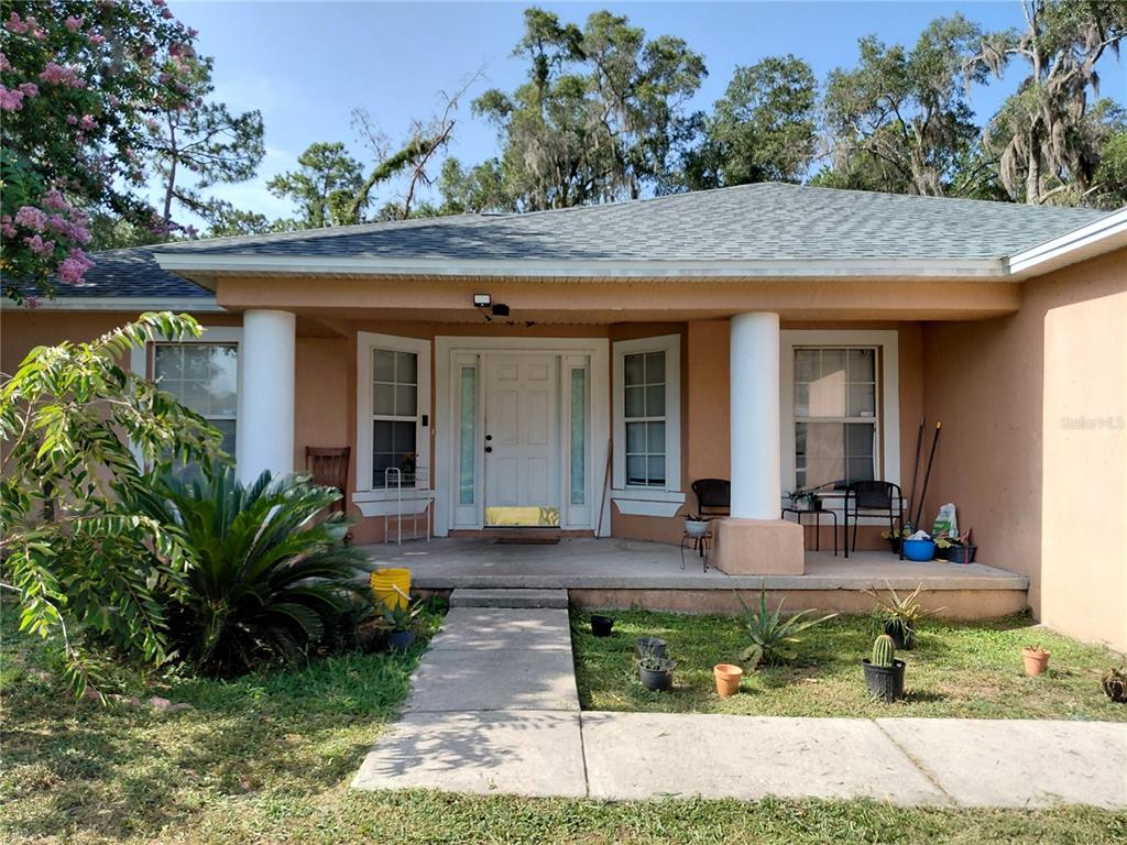 A single-story house with a covered porch, two white columns, and a concrete walkway — 2716 NE 24TH PLACE, OCALA, FL