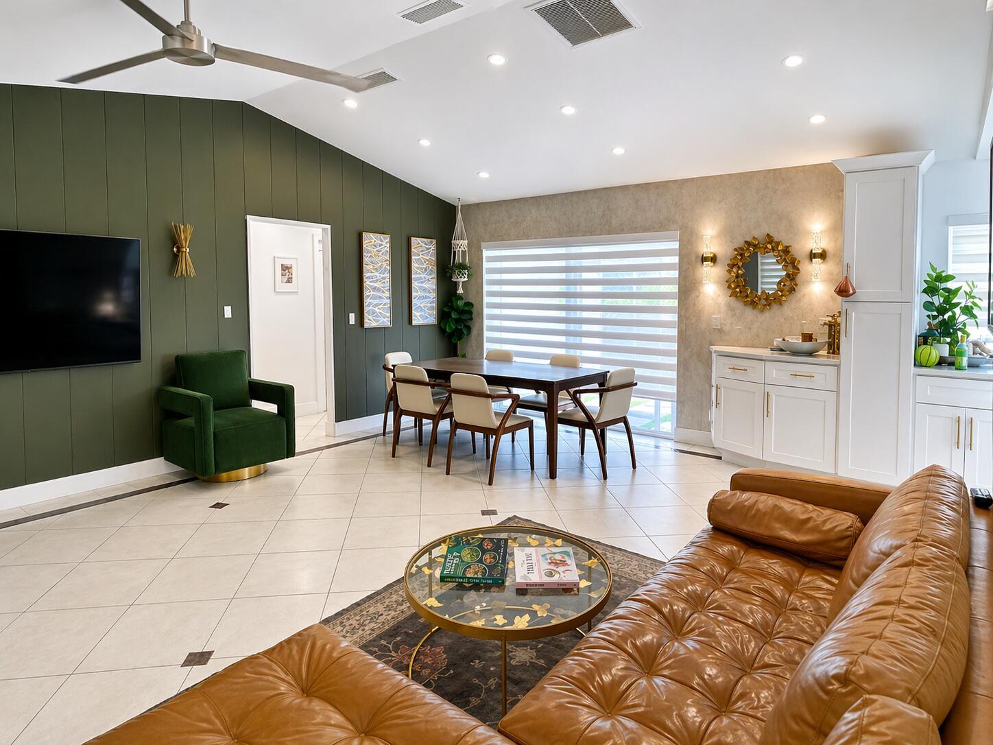 A living and dining room featuring a green accent wall, leather sofa, and tile flooring — 7971 Chula Vista Crescent, Boca Raton FL 33433, BOCA RATON, FL