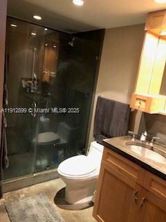 A bathroom features a glass-enclosed shower, a white toilet, and a wooden vanity cabinet — 1688 West Ave # 405, Miami Beach FL 33139, MIAMI BEACH, FL