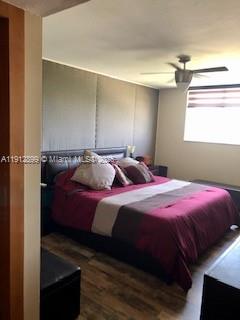 A bedroom features a bed with a maroon comforter, a ceiling fan, and wood flooring — 1688 West Ave # 405, Miami Beach FL 33139, MIAMI BEACH, FL