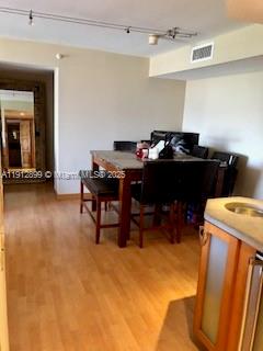 A dining area with a wooden table and chairs sits on light-colored wood flooring — 1688 West Ave # 405, Miami Beach FL 33139, MIAMI BEACH, FL