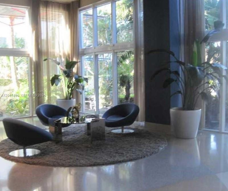 A modern living area features three dark chairs arranged around a glass coffee table — 6365 Collins Ave # 1707, Miami Beach FL 33141, MIAMI BEACH, FL